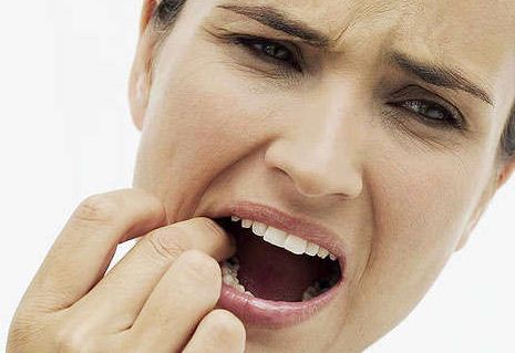 Toothache causes include sinus-related gum pain, recent root canals, cavities, and tooth abscesses. This is an image of a woman experiencing dental pain.