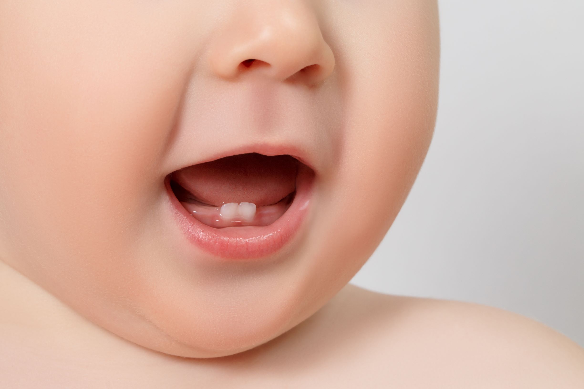 Baby teeth can be fascinating. The two middle teeth on the bottom jaw tend to poke through first, as shown in this picture of a smiling baby.