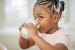 Drinking milk, like this young girl is doing, during or after a meal can help neutralize acids in your mouth, as well as provide you with nutrients that keep bones and teeth strong.
