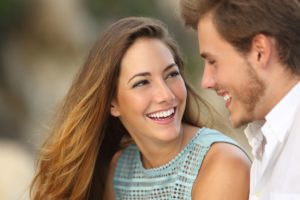 There are many effects of misaligned teeth that others do not see. Straightening your teeth can help you smile with greater confidence, like the young couple in this image.