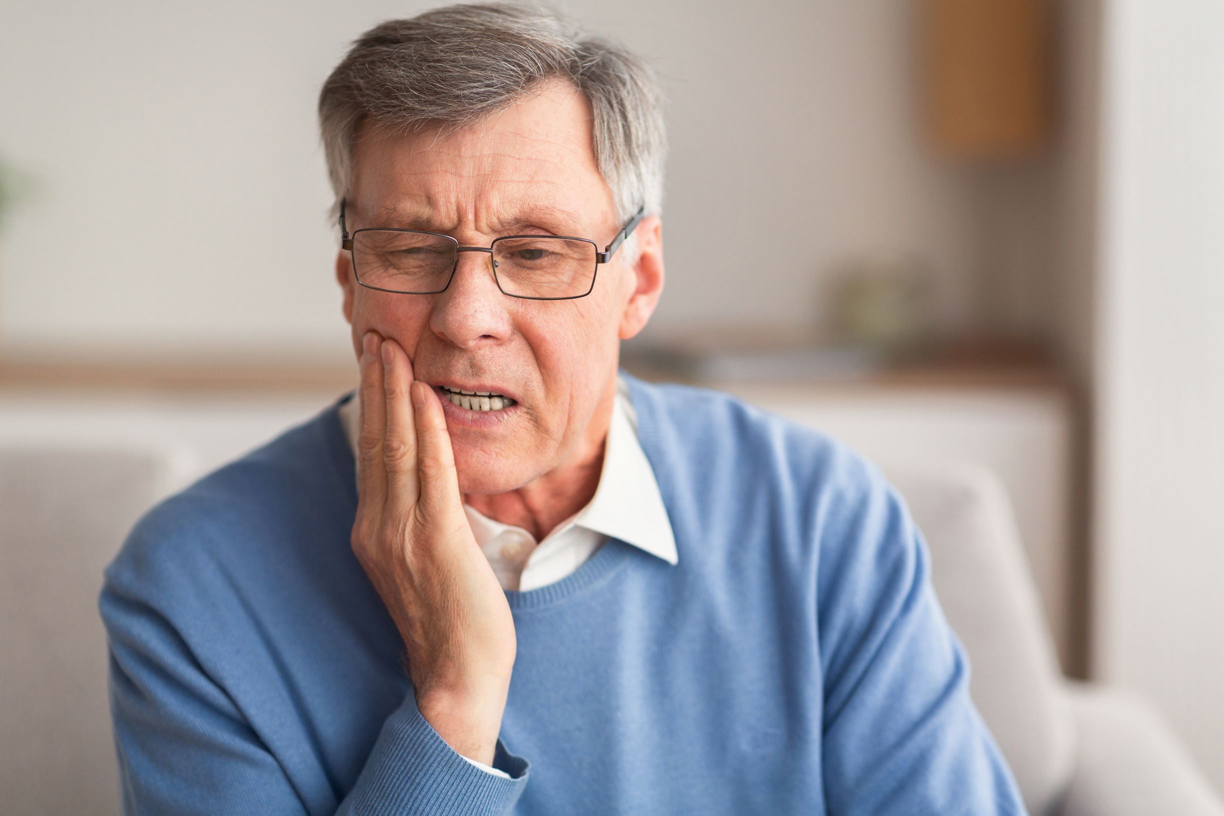 What is a tooth abscess? How is a tooth abscess treated? If you are experiencing dental pain like the man in this image, you may wish to ask our Grosse Pointe dentist if you have a tooth infection.